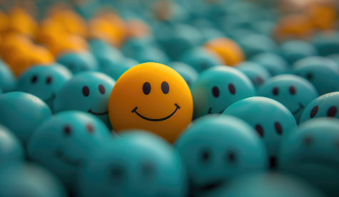 An image of a yellow face in a sea of blue faces.