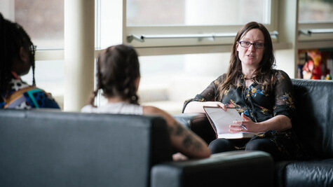 A student social worker sat talking to clients.