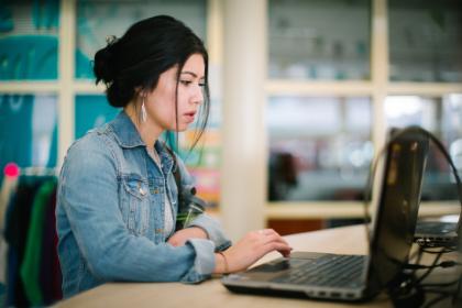 A student working at a laptop.