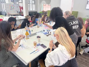 A group of students crafting and painting around a table.