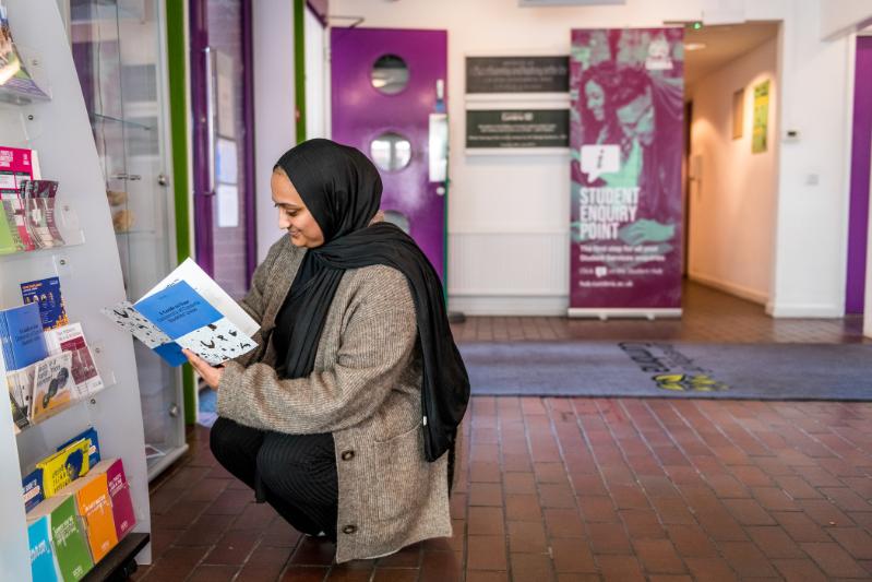London Campus Student Looking at Booklet