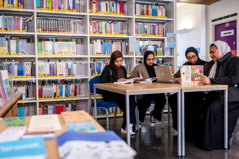 A group of students working together round a desk.