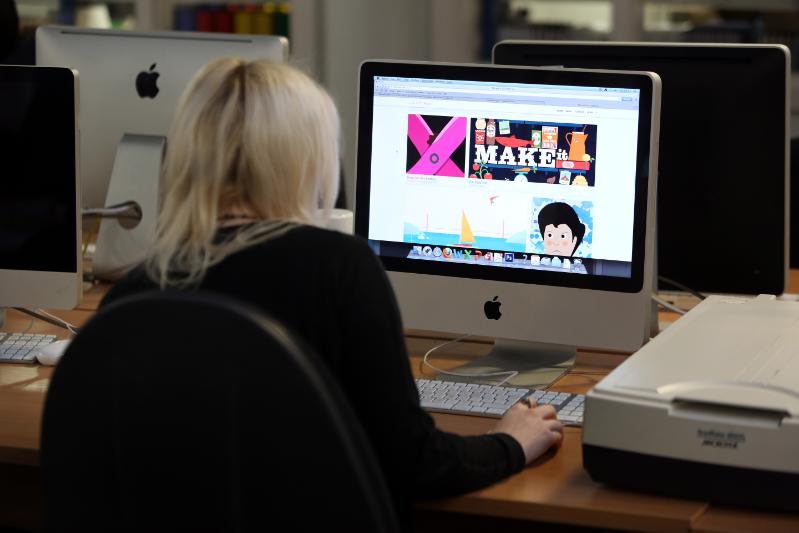 Looking over a student's shoulder at a computer screen. 