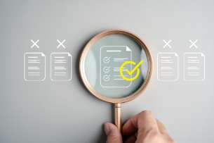 An image of a magnifying glass looking at an icon of a document.