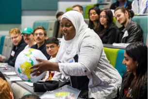 An image of a student teacher holding a globe.