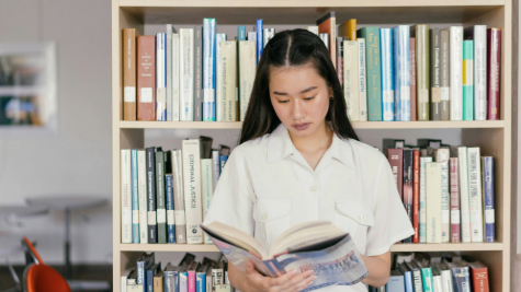 A young woman consulting a book in a library