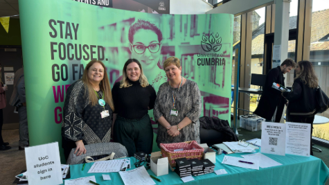 3 members of the careers team staff stood behind a table at an event