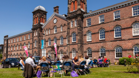 People sitting on chairs on a university lawn