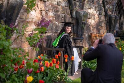 A girl being photographed in a UOC gown at graduation
