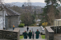 Students walking through Ambleside campus with a scenic background.