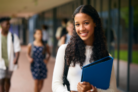 An image of a student smiling  holding a folder.