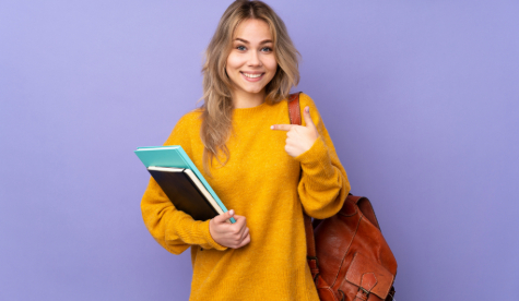 An image of a student smiling holding training material.